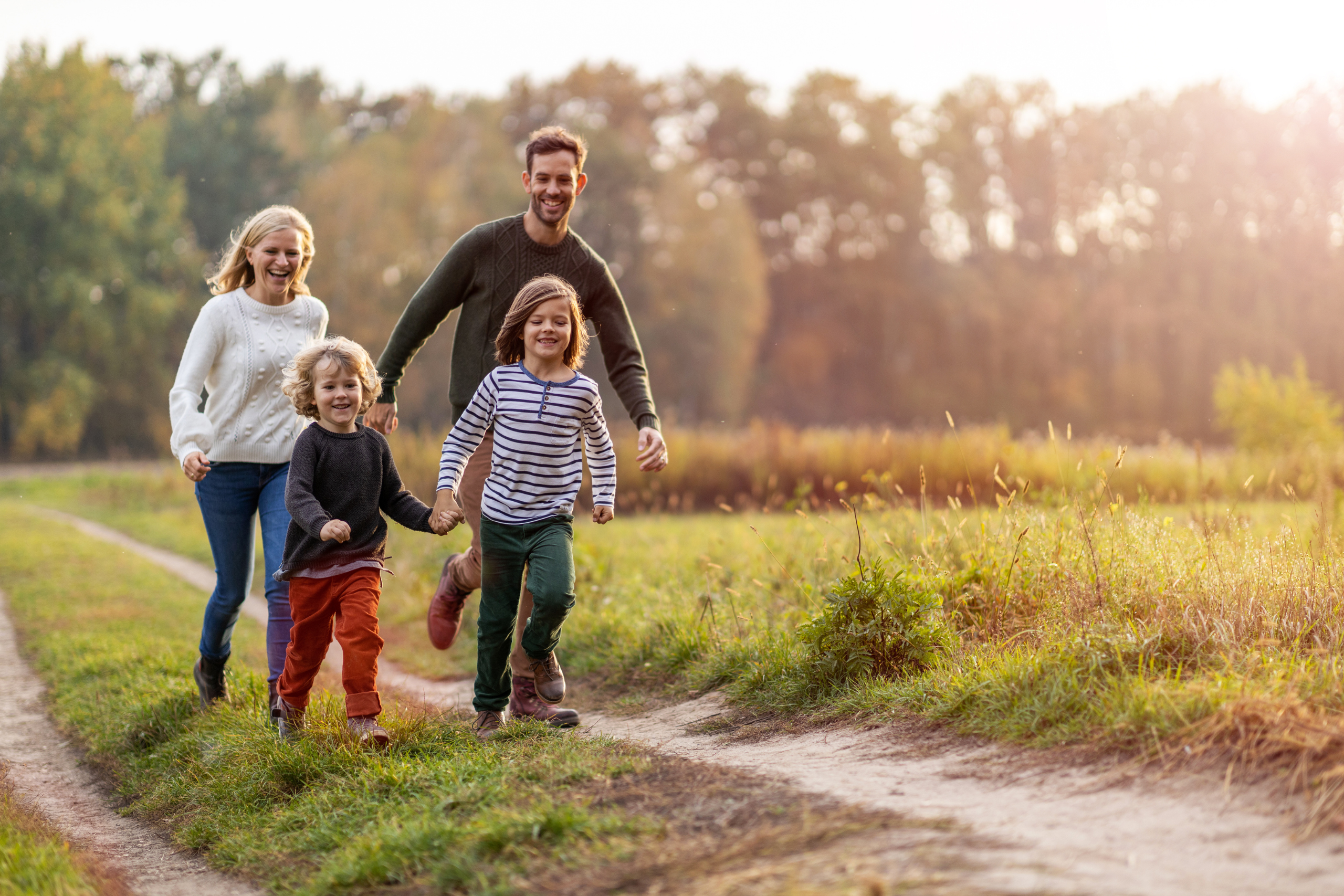 Familie läuft einem Feldweg entlang